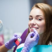Dentist curing a woman patient in the dental office in a pleasant environment. There is specialized equipment to treat all types of dental issues in the office.