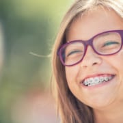Young girl smiling while wearing braces.
