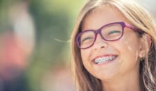 Young girl smiling while wearing braces.